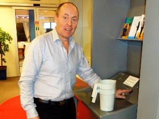Ordfrar Arne Bergsvg kan smilande trykkja p startknappen til teljemaskina i banken.